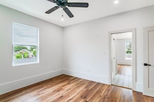 Modern light-filled room with hardwood flooring and ceiling fan in New Orleans.